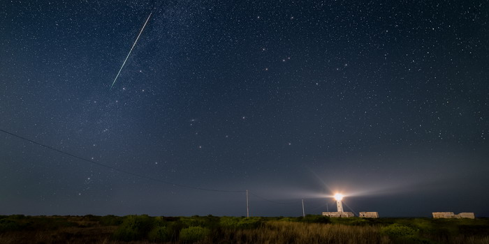 L'evocativo Faro del Plemmirio avvolto nella notte sotto il cielo di stelle attraversato da una perseide